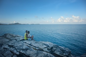 Man and Woman Sitting Near Body of Water