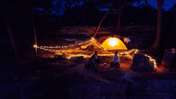 Man and Woman Sitting Near Outdoor during Nighttime