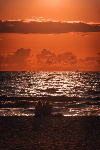 Man and Woman Sitting Near Shore
