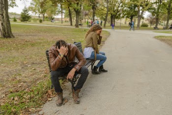Man And Woman Sitting On Bench
