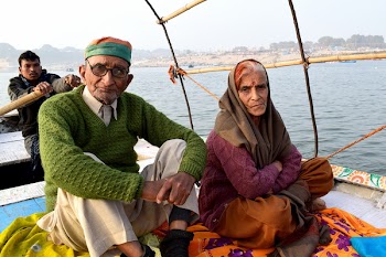 Man and Woman Sitting on Boat Under White Clouds