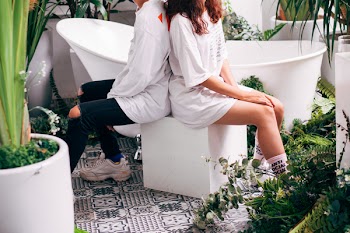 Man and Woman Sitting on Brown Wooden Box