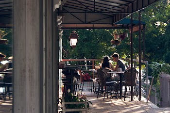 Man and Woman Sitting on Chair Near Hand Railings
