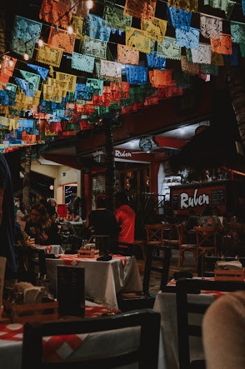 Man and Woman Sitting on Chairs Under the Buntings
