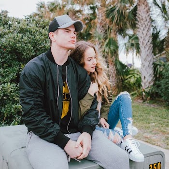man and woman sitting on gray surface