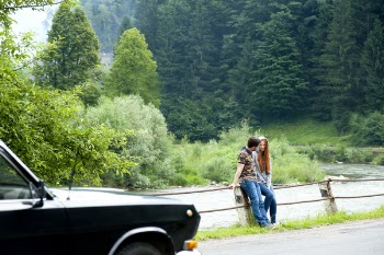 Man and Woman Sitting on Road Gutter