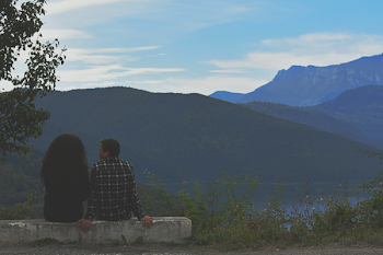 Man and Woman Sitting on Rock