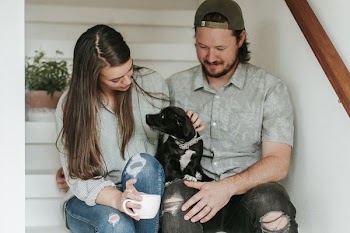 man and woman sitting on stairs with dog