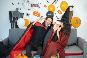 Man and Woman Sitting While Wearing Halloween Costumes