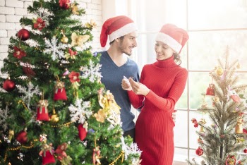 Man and Woman Standing Beside Christmas Tree