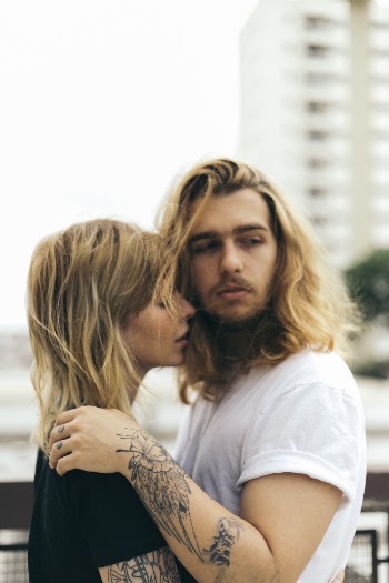 Man and Woman Standing Beside Fence