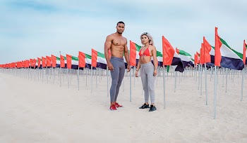 Man and Woman Standing in Front of Red, White, Green, and Black Flags