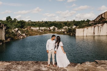 Man and Woman Standing Near Lake during Cloudy Day Time
