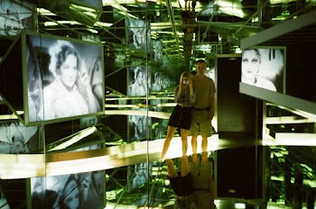 Man and Woman Standing Near Photo of Woman Inside Glass Room