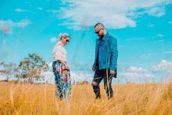 Man and Woman Standing on Brown Grass