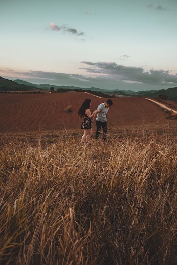 Man And Woman Standing On Brown Grass Field