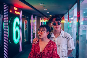 Man and Woman Standing on Hallway Surrounded by Led Lights