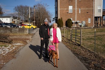 Man and Woman Standing on Street Beside Short-coated Dog