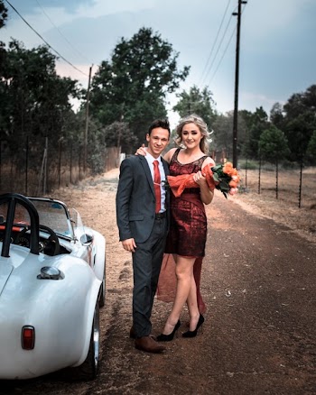 Man and Woman Taking Photo Beside White Coupe