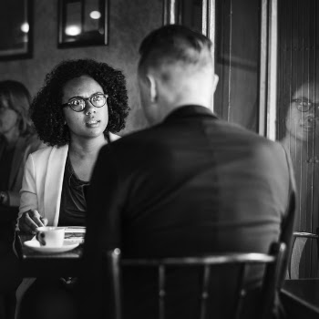 Man and Woman Talking to Each Other While Sitting on Chair