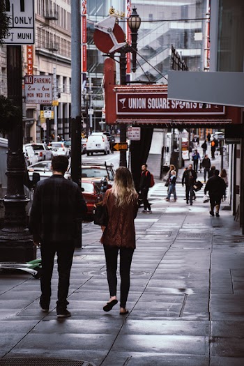 Man and Woman Walk Beside Store
