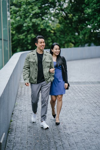Man and Woman Walking Beside A Building