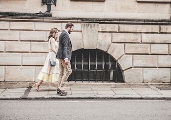 man and woman walking beside a road during daytime