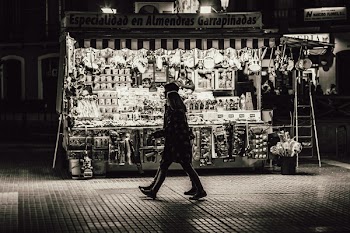 Man and Woman Walking in Front of Store Greyscale Photo