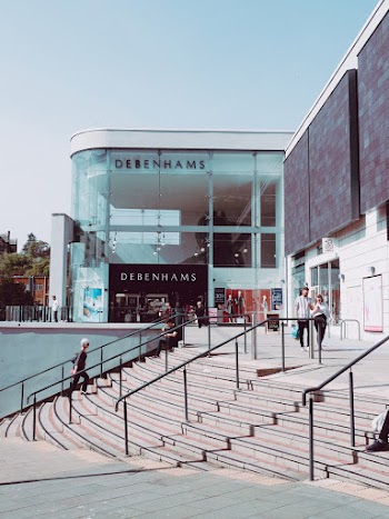 Man and Woman Walking Near Store and Stairs