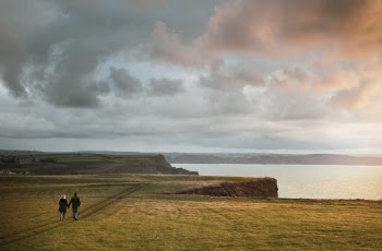 Man and Woman Walking on Gras