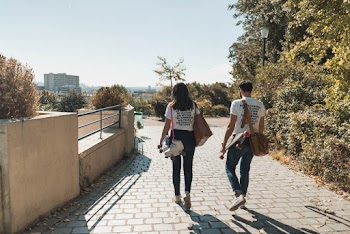 Man and Woman Walking on Paved Bricks