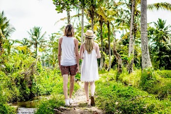 Man And Woman Walking Towards Palm Trees