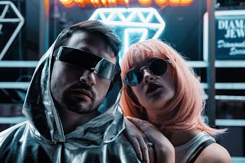 man and woman wearing sunglasses near neon signage
