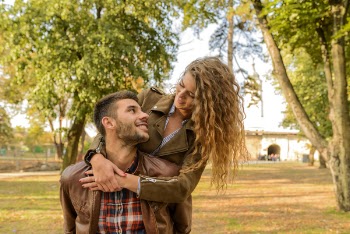 Man and Woman Wearing Wearing Brown Leather Jacket Near Green Leaf Tree
