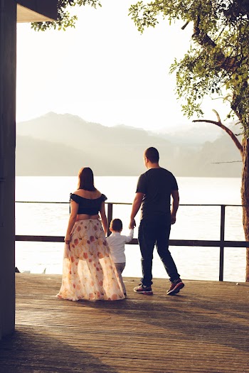 Man and Woman With Child Walking Near Railings