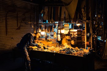 Man Beside Fruits during Nighttime