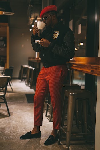 Man Black Leather Jacket and Red Cap Holding Cup and Saucer