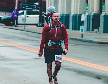 Man Carrying Baby at Back While Walking Near Buildings