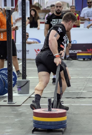 Man Carrying Barbell Plate Outdoors