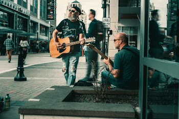 Man Carrying Brown Acoustic Guitar