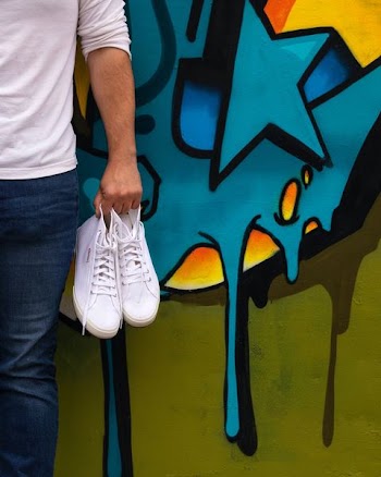 man carrying pair of white high-top sneakers