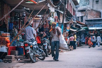 man carrying sack in street near market