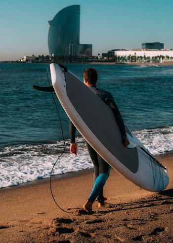 Man Carrying White Surfboard