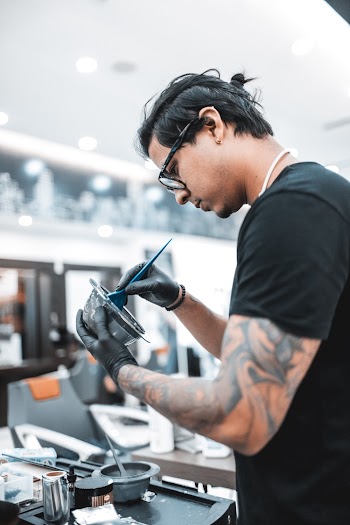 Man Cleaning Gray Metal Tool With a Brush