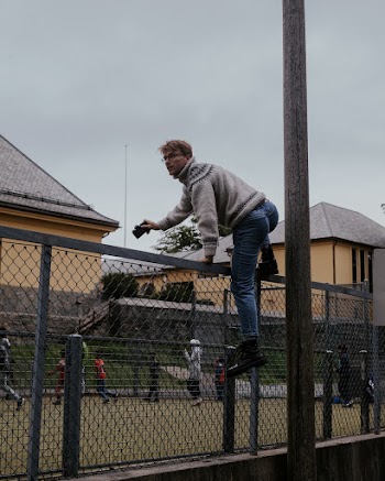 Man Climbing Fence