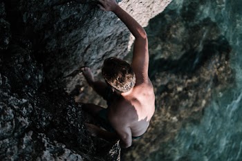 Man Climbing On Cliff