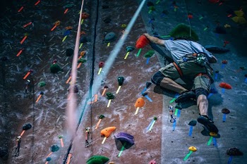 man climbing wall with harness