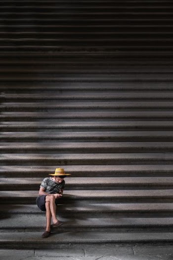 man crossing his legs sitting on staircase