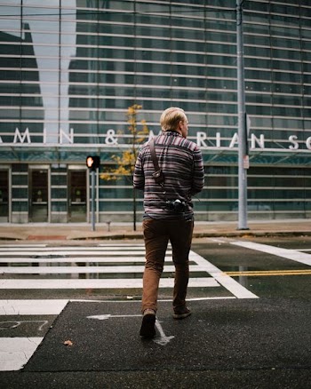 man crossing pedestrian lane during daytime