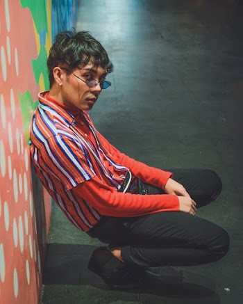 Man Crouching Against a Wall